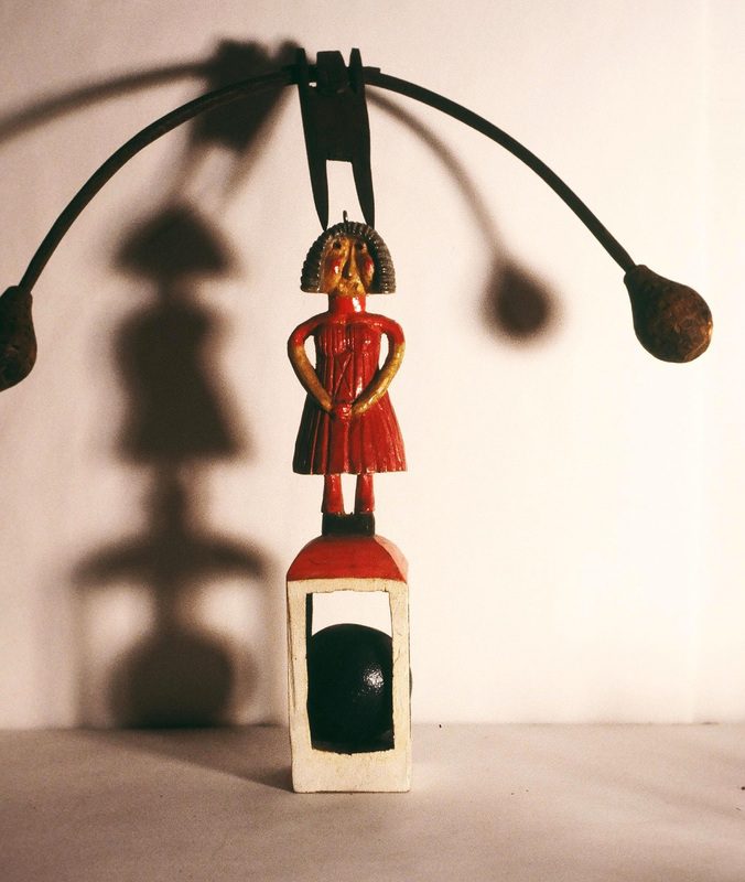 A wooden doll is standing on top of a table.